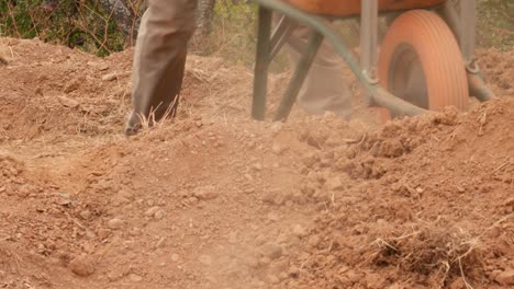 dumping-the-dirt,-sand-and-dust-from-a-wheelbarrow,-4k-video