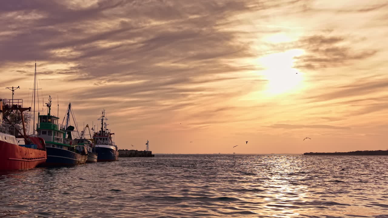 Vista mozzafiato di un tramonto su un tranquillo porto con barche da pesca immerse in tonalità dorate