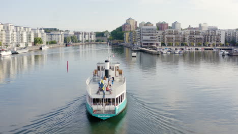 Kleines-Kreuzfahrt-Fährschiff,-Das-In-Den-Hafen-Einfährt,-Docking-Dock,-Schwimmende-Transithaltestelle,-Busse,-Fahrerkapitän,-Nähert-Sich-Dem-Schwedischen-Linienschiff,-Segelflagge,-Die-Ozean-Seehafen-Vintage-Dampfmaschine-Schwenkt