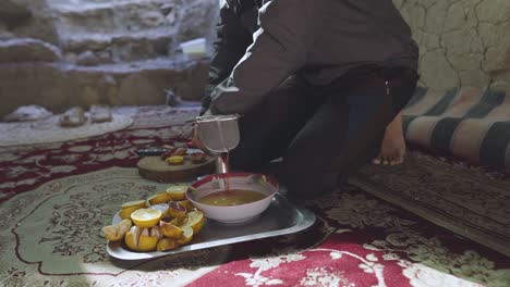 making orange juice the fresh fruit extract handmade by pressure cutting oranges in half and squeeze to get organic delicious drink in desert rural village traditional town in iran nayband tabas saudi