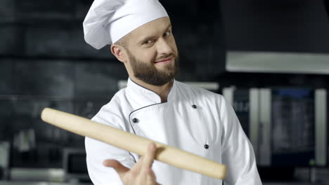 szef kuchni grający z rolką w kuchni. portret profesjonalnego szefa kuchni