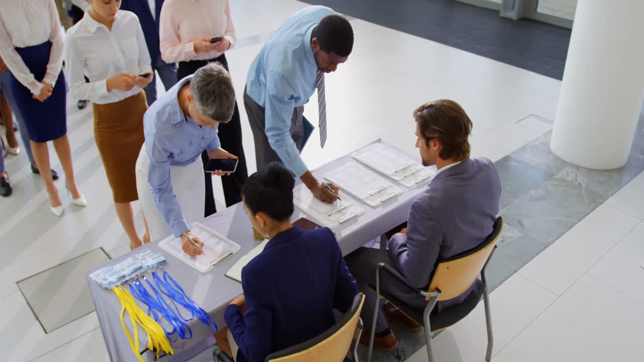 gente de negocios registrándose en la mesa de registro de la conferencia 4k