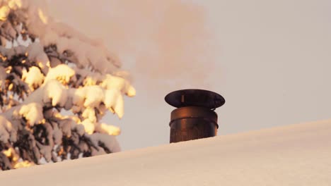 Weißer-Rauch-Tritt-Im-Winter-Aus-Dem-Schornstein-Auf-Dem-Schneebedeckten-Dach-Aus