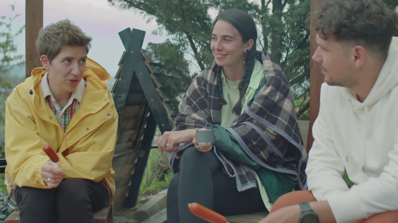 Company of Friends Chatting while Cooking Meal over Campfire