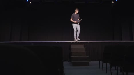 caucasian teenage boy in the high school auditorium preparing for a performance