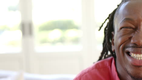 Half-portrait-of-happy-african-american-man-with-dreadlocks-smiling-in-sun,-copy-psace,-slow-motion