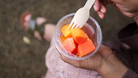 woman eating papaya salad outdoors