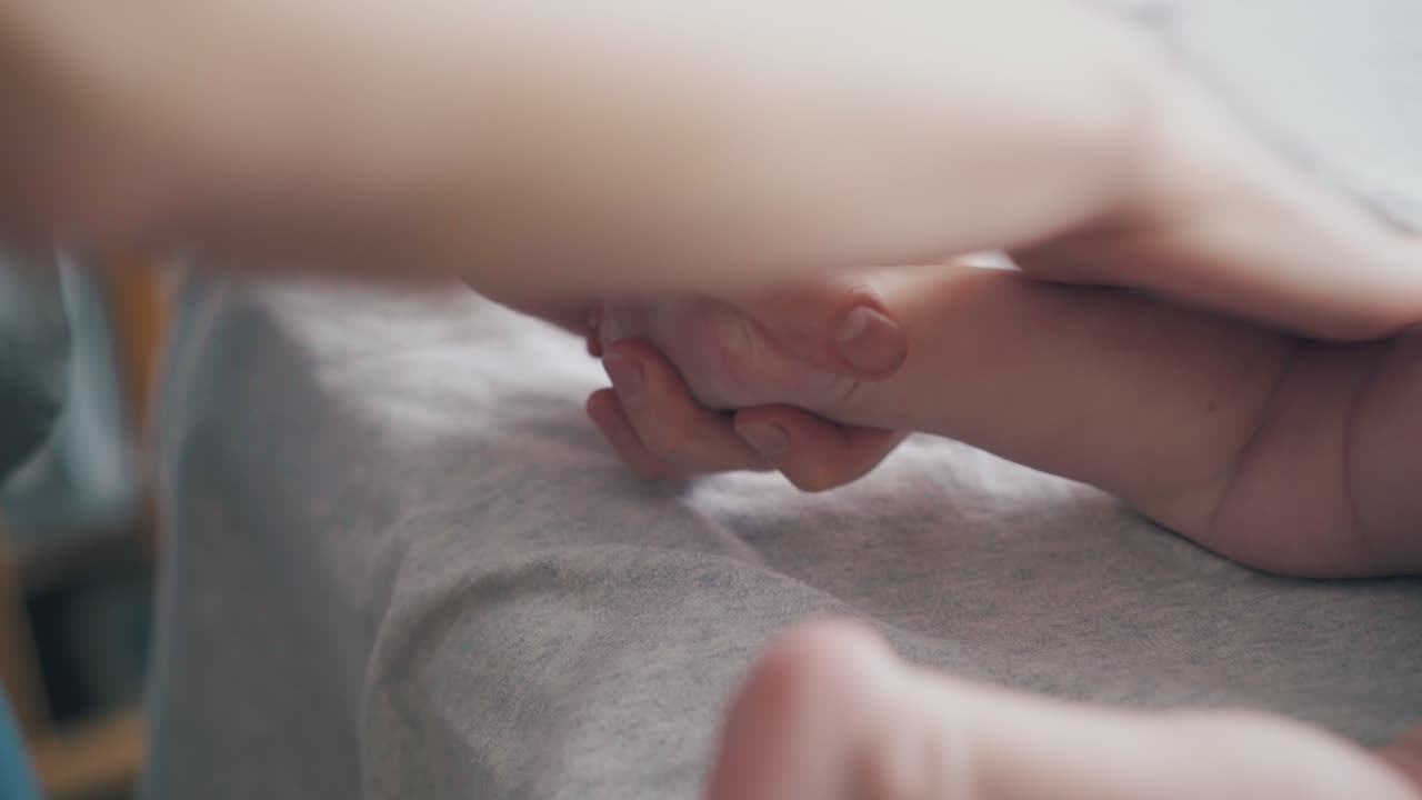 소아과 의사의 손은 고혈압 아기 마사지를 연습합니다.