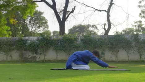 man doing yoga in a park