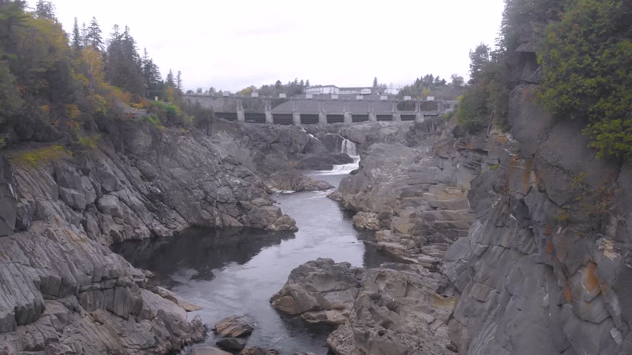 카메라가 그랜드 폭포라고 불리는 폭포를 향해 밀어내면서 절벽 사이의 을 천천히 밀어넣습니다.