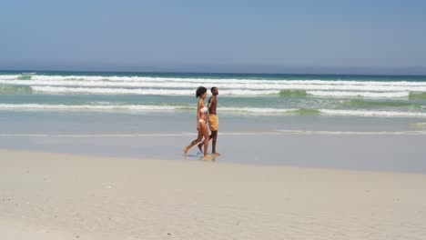pareja romántica caminando de la mano en la playa 4k