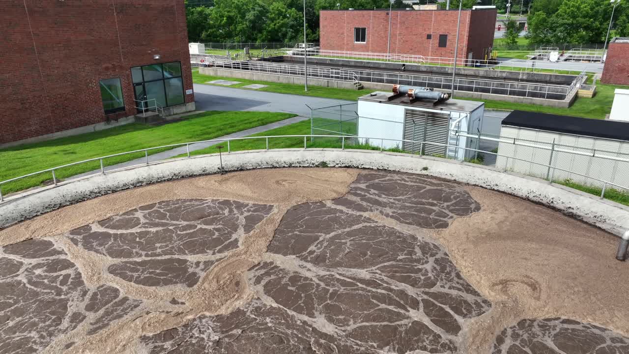 Aerial close up of wastewater treatment plant, filtration of dirty or sewage water. Sewage treatment plant at sunny day