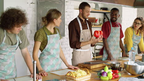 chef speaking to young multiethnic people at cooking master class