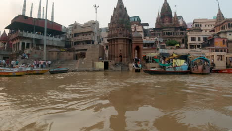 Cinematográfico-Gente-Se-Reúne-Ganges-Río-Crucero-Chowk-Canal-Barco-Varanasi-Norte-India-Estado-Antiguo-Ciudad-Santa-Khidkiya-Ghat-Pradesh-Provincia-Paisaje-Gris-Nublado-Todavía-Tranquilo-Fangoso-Marrón-Tarde-Movimiento