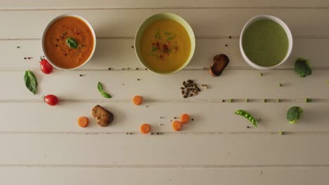 video de diversas sopas de verduras de crema con ingredientes sobre una superficie blanca