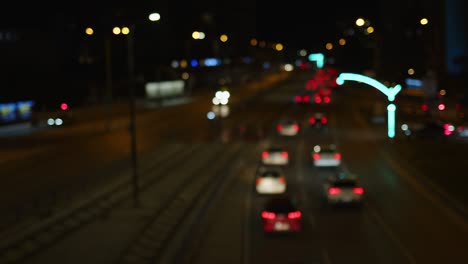 la vida de la ciudad borrosa tráfico de coches por la noche