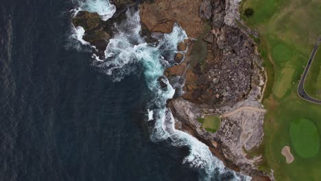 waves splashing on rocky shore of little bay beach in sydney, new south wales, australia - aerial top down