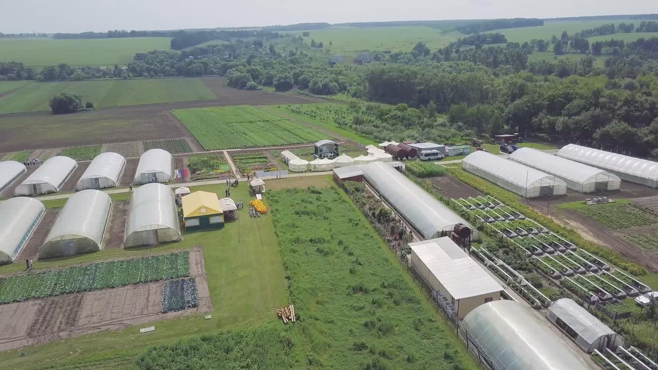 Vista aérea de una granja agrícola con invernaderos y espacio para eventos