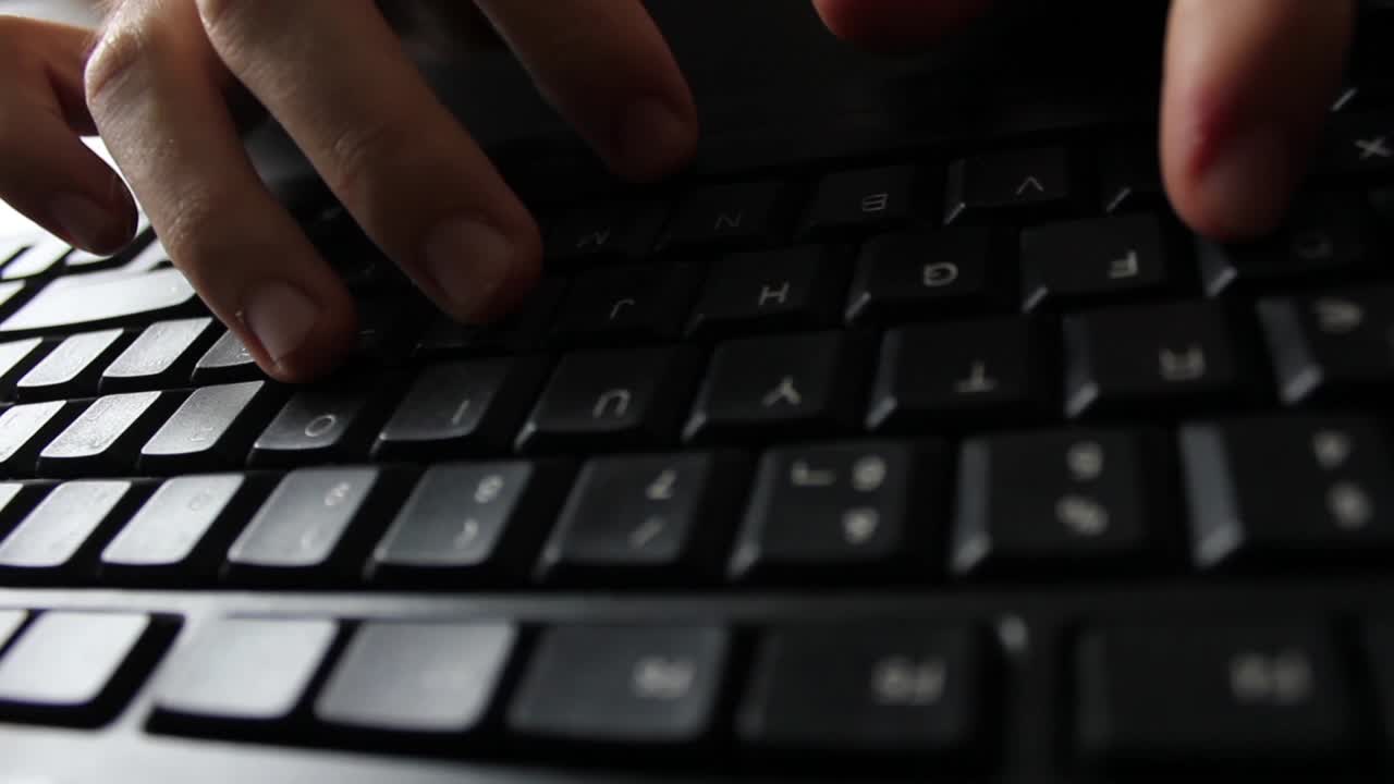 Close-up of Hands Typing on a Black Computer Keyboard