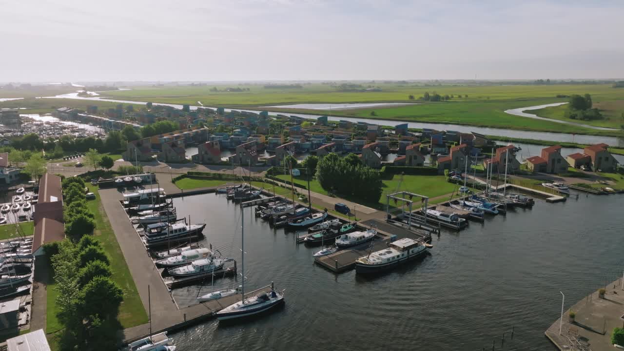Drone captures a semi orbit around Heeg’s marina, revealing clustered boats and waterfront homes under soft morning light.