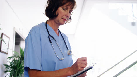 nurse writing a report on clipboard