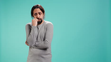 distraught man biting nails, being afraid of receiving troubling bad news