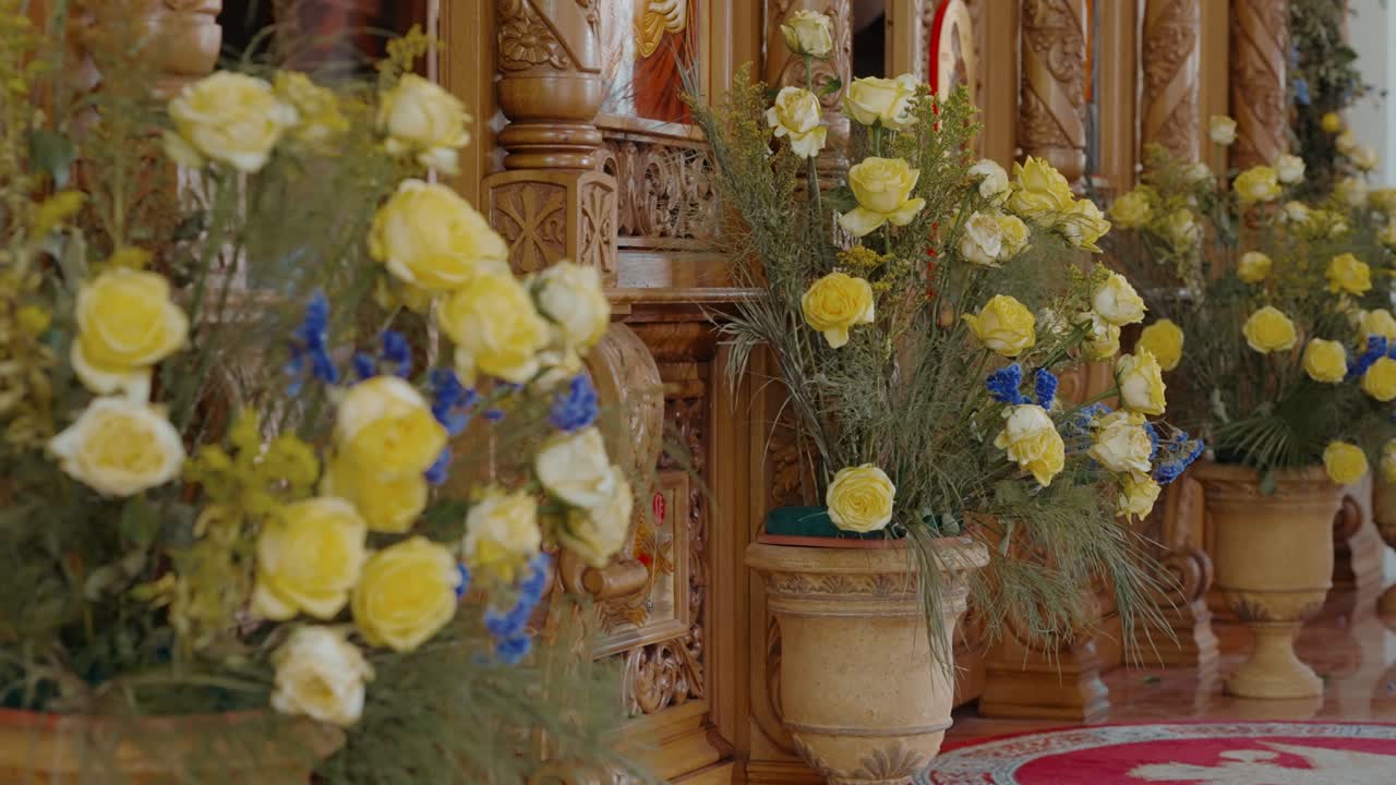 pequeña órbita de vibrante rosa amarilla y azul delphinium arreglos florales que adornan el altar de la iglesia ortodoxa