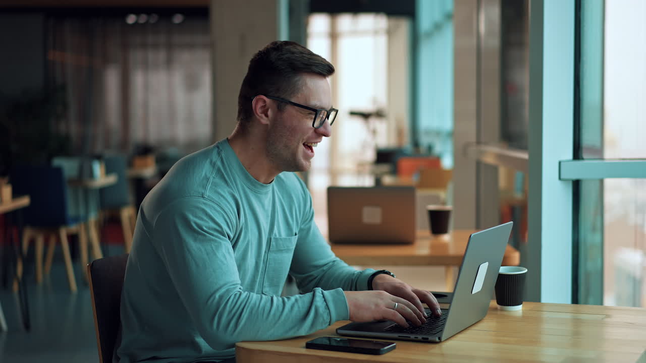 un hombre trabajando en una computadora portátil en un café