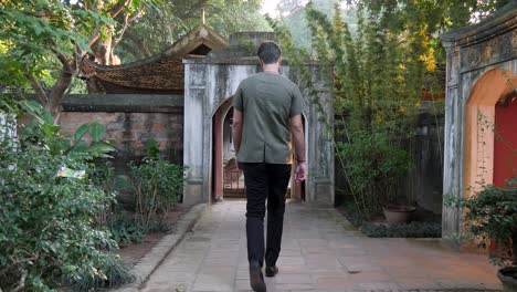 young man walking confident like a model towards and through archway