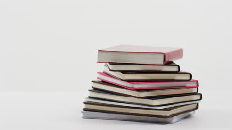 acercamiento de una pila de libros sobre un fondo blanco, en cámara lenta