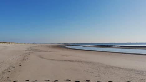 aerial, rising drone shot over a river at a beach, sunny day, at the nordsee, langeoog, north germany