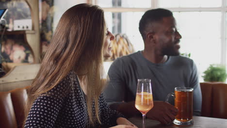 grupo de amigos que se reúnen para tomar una copa a la hora del almuerzo en un pub inglés tradicional