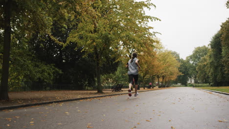 Runner-woman-running-in-park-exercising-outdoors-fitness-tracker-wearable-technology