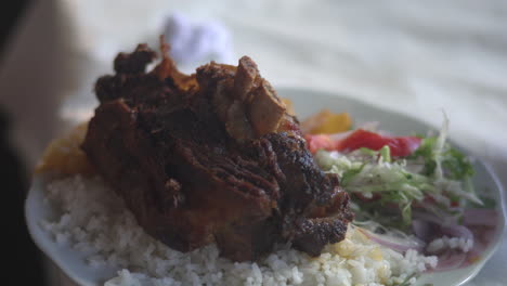 Una-Imagen-En-Primer-Plano-Que-Captura-Un-Sabroso-Plato-Tradicional-De-Cerdo-En-Cusco,-Perú,-Conocido-Como-&quot;chicharrón-De-Chancho&quot;,-Servido-Con-Arroz-Y-Acompañado-De-Verduras