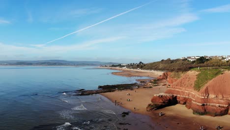 aerial of orcombe beach and cliff coastline in exmouth with visitors on beach on sunny day