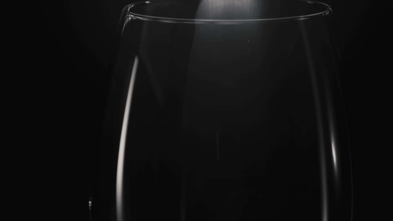 Ice cube falls empty glass closeup. Refreshing cocktail preparation concept