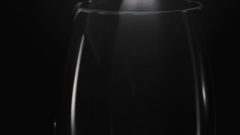 el cubo de hielo cae en un vaso vacío de primer plano. refrescante concepto de preparación de cócteles