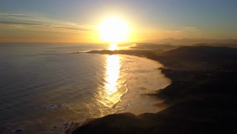 big stunning orange sunset over south african coast, knysna, aerial drone left motion