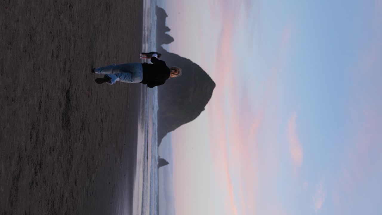 mujer corriendo en cannon beach, oregón al atardecer - libertad, deseo de viajar concepto
