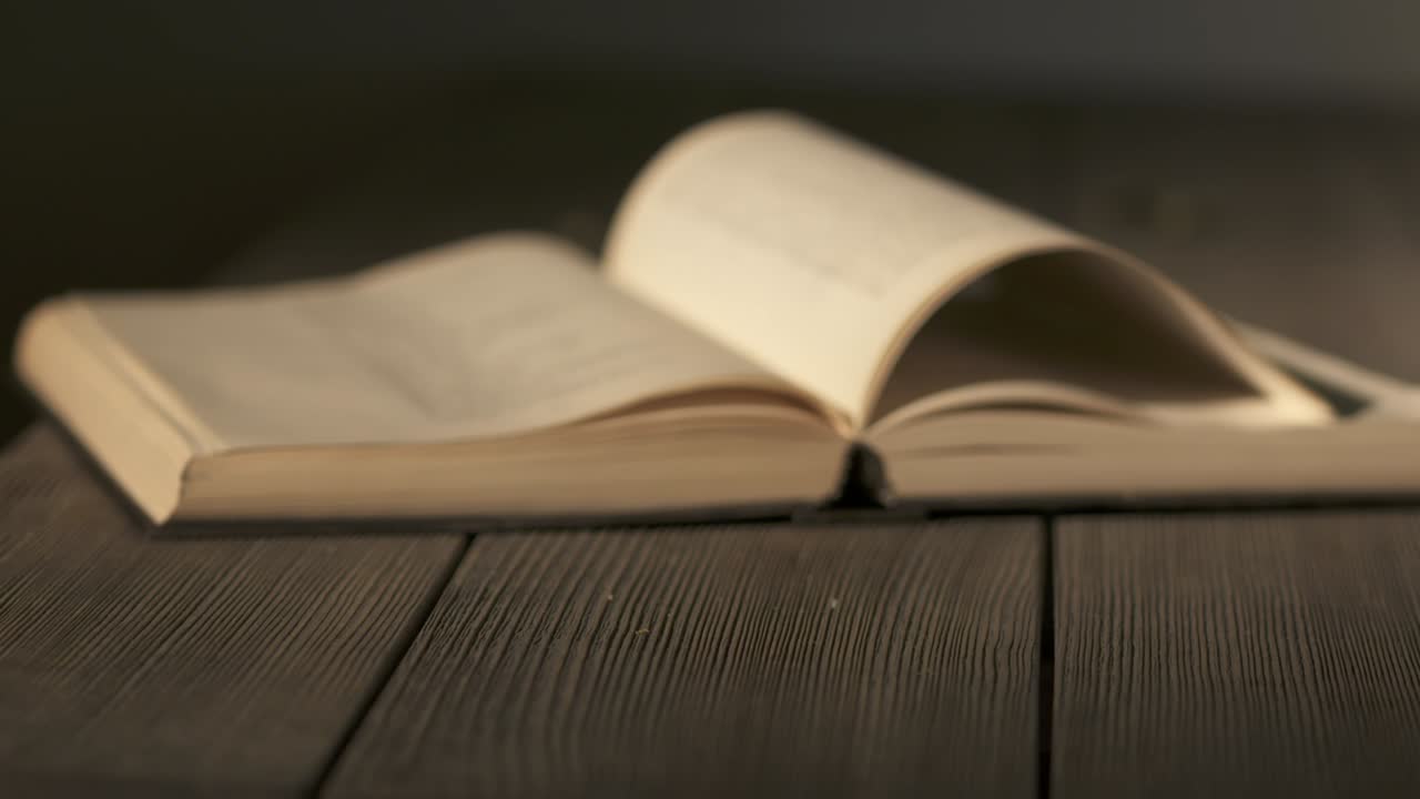 libro abierto en una mesa de madera en una habitación oscura