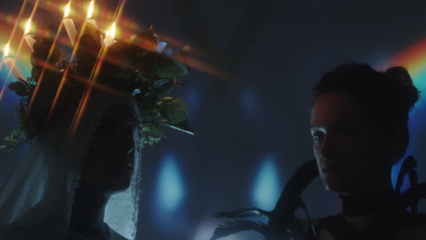 man and woman in creative costumes in dark studio