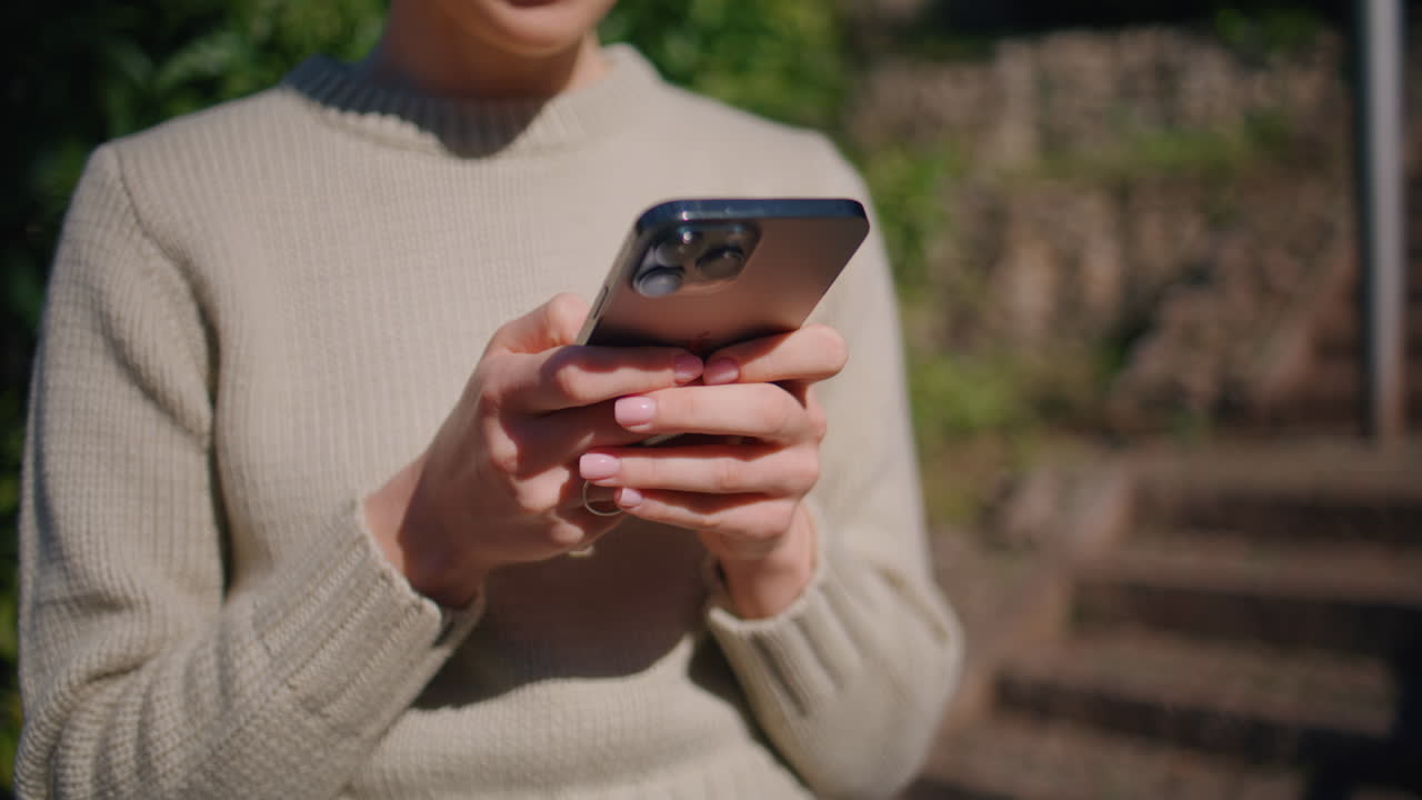 Girl hands texting mobile phone walking sunny park closeup. Woman typing screen