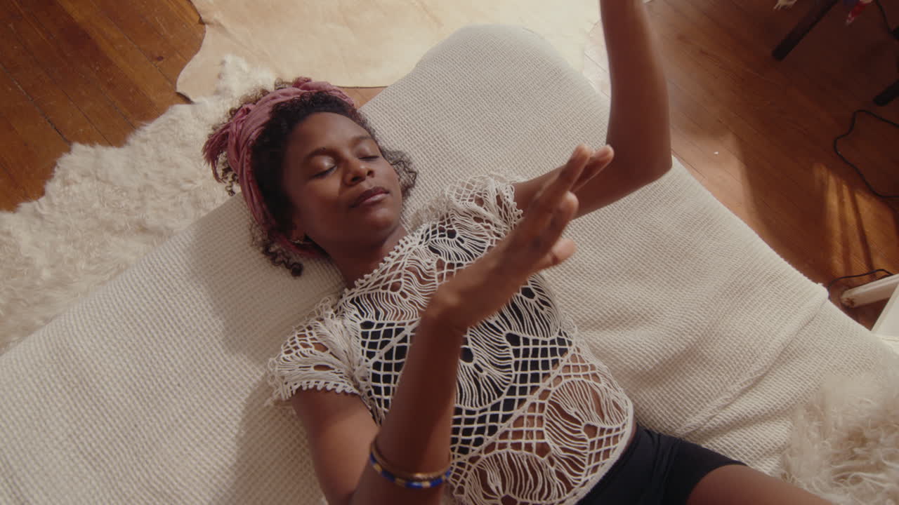 Girl Lying on Bed with Eyes Closed, Enjoying the Music and Dancing