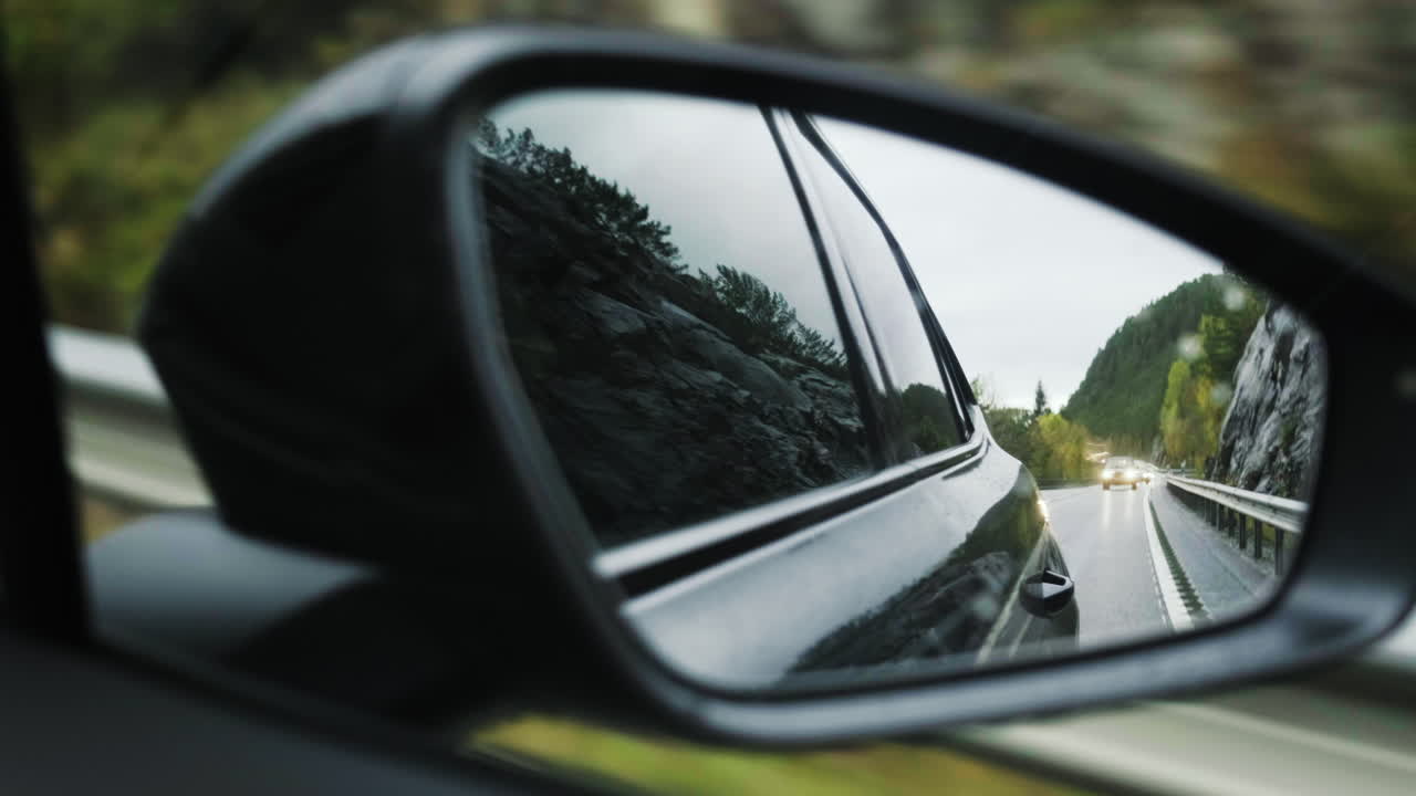 Specchietto retrovisore - Specchietto retrovisore di un'auto nera che guida sulla strada.