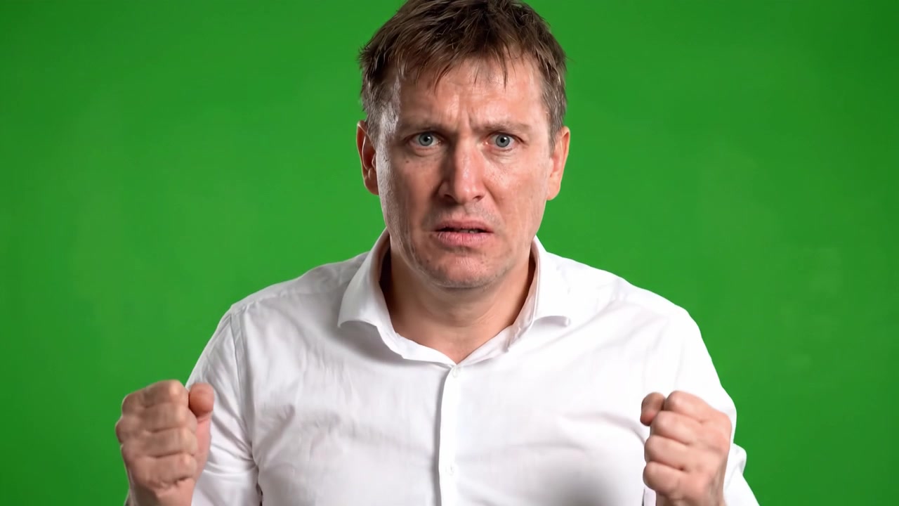 Dramatic Expressions Captured: A Man Conveying Intensity and Emotion Against a Green Screen Backdrop