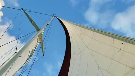 this is 4k video of a sailboats mast and sail rocking back and forth on the ocean