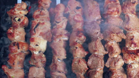 Grilling-food-on-mangal.-Rotate-skewers-with-roasted-meat.-Prepared-food.-Macro