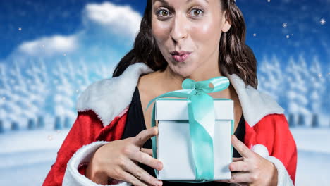 animation of happy caucasian woman keeping present wearing santa clothes over winter scenery