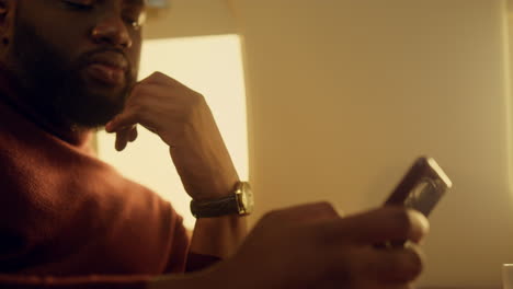 Focused-guy-looking-smartphone-at-airplane-window-closeup.-Hands-holding-cell