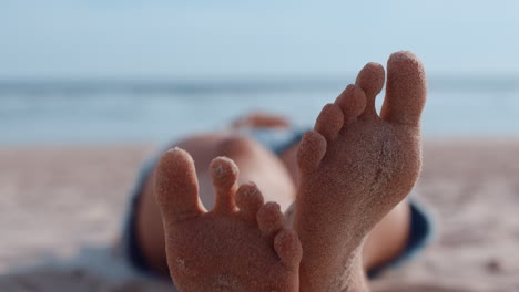 cerca de los pies de la mujer relajándose en la playa turista disfrutando de unas cálidas vacaciones de verano en la costa tropical